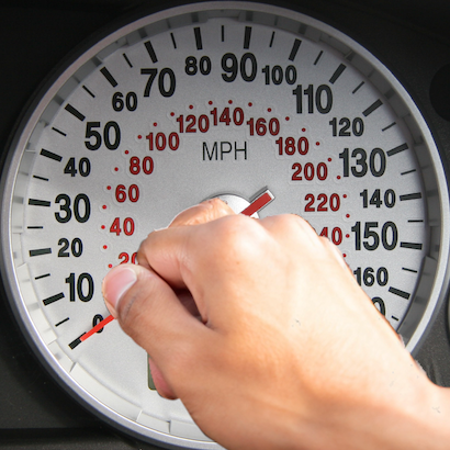 Image of a human hand forcing a speedometer dial to 0